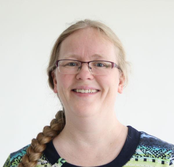 Portrettbilde av kvinne med briller og langt lyst hår i flette. Foto - Klikk for stort bilde